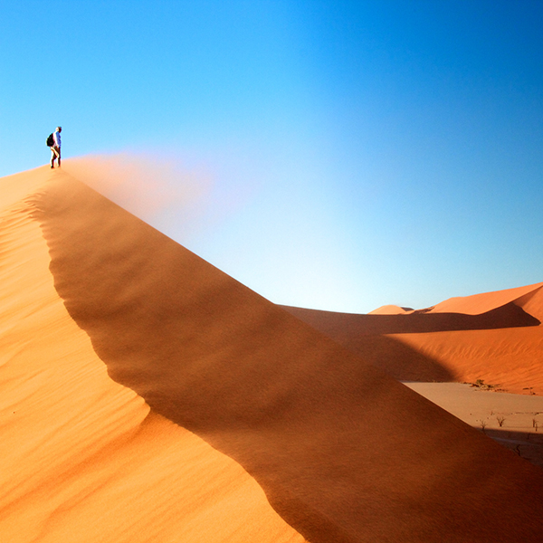 Man standing on sand dune Sossusvlei Nambia Africa